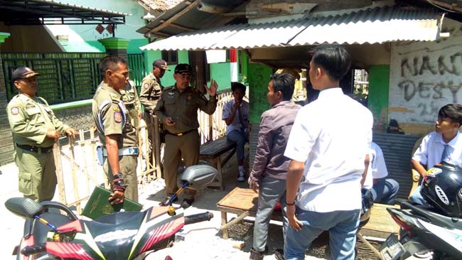 Satpol PP Sampang saat melakukan penertiban kepada siswa yang berkeliaran saat jam sekolah di Jalan Durian. (zyn)