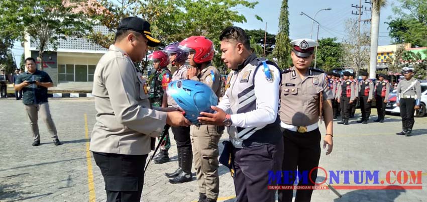 Kapolres Sampang AKBP Didit BWS saat menyerahkan helm kepada anggota Polres, TNI, Satpol PP dan Dinas Perhubungan Sampang. (zyn)