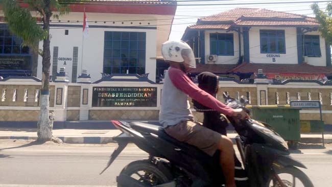 Pengendara saat melintas di depan Dinas Pendidikan Sampang. (zyn)