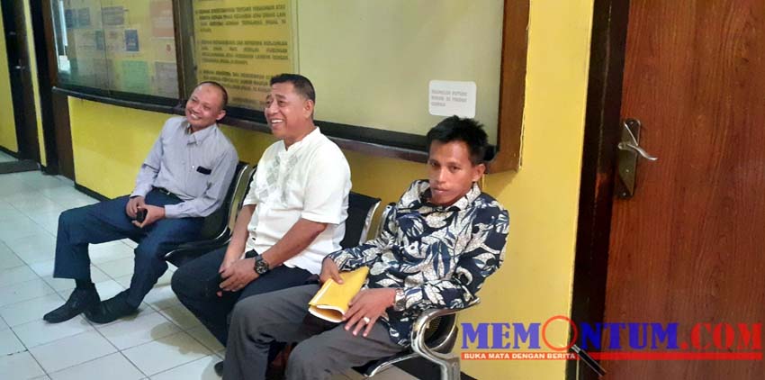 Martuli (memegang berkas warna kuning) didampingi oleh kedua kuasa hukumnya saat melapor ke SPKT Polres Sampang. (zyn)